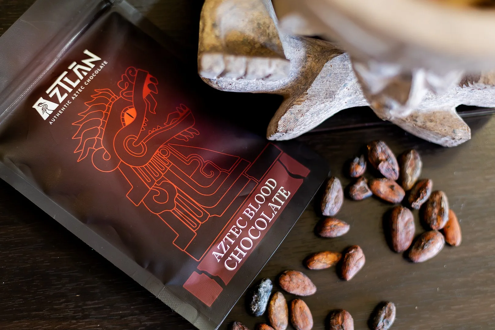 AztecBlood pouch lying with raw cacao beans and a carved bowl