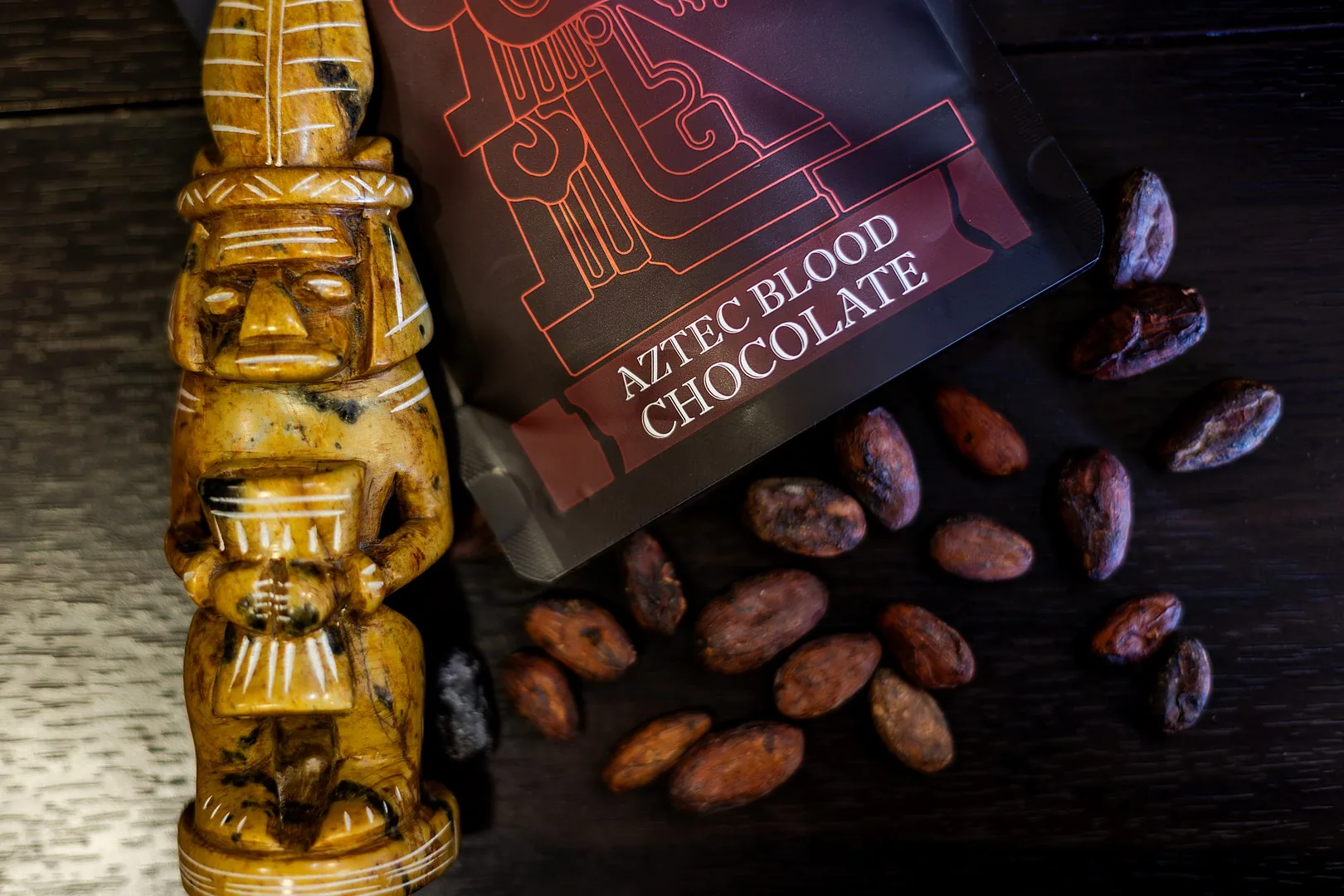 AztecBlood pouch with Aztec idol and scattered cacao beans, top-down